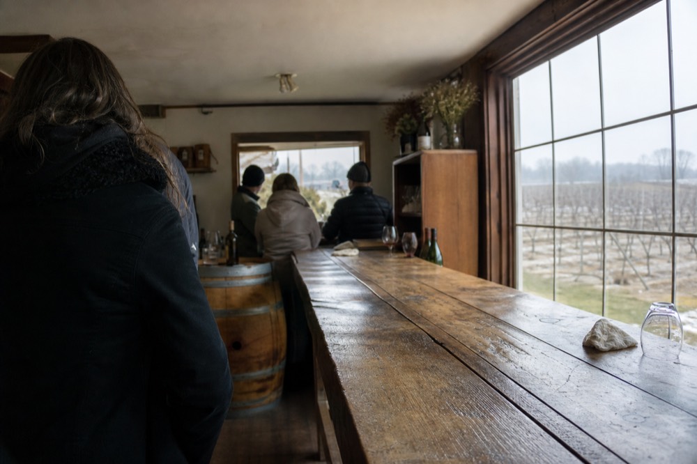 Long wooden tasting bar in a small family winery tasting room, no text, no logos, no people
