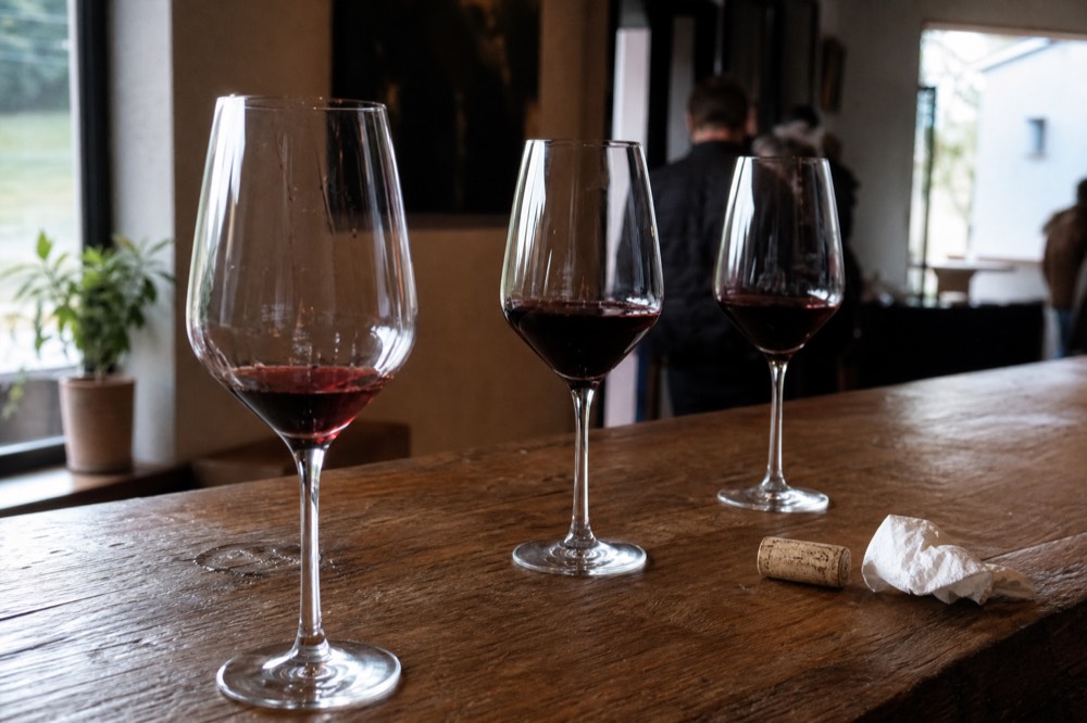 Flight of red wines on a tasting room bar, no text, no logos, no people
